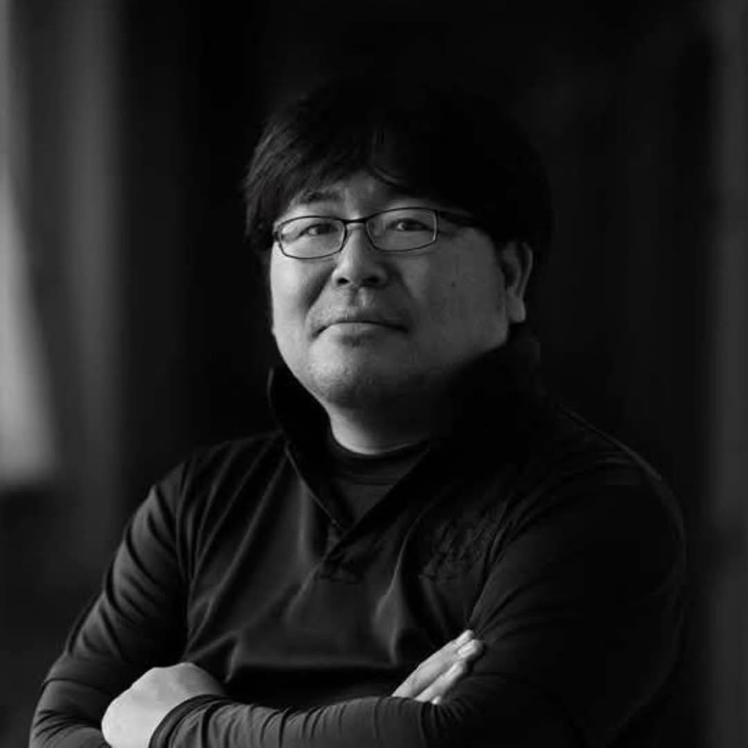 磐田物語を書いている大石浩之の顔写真。眼鏡をかけ、腕を組んで正面を向いたモノクロの肖像